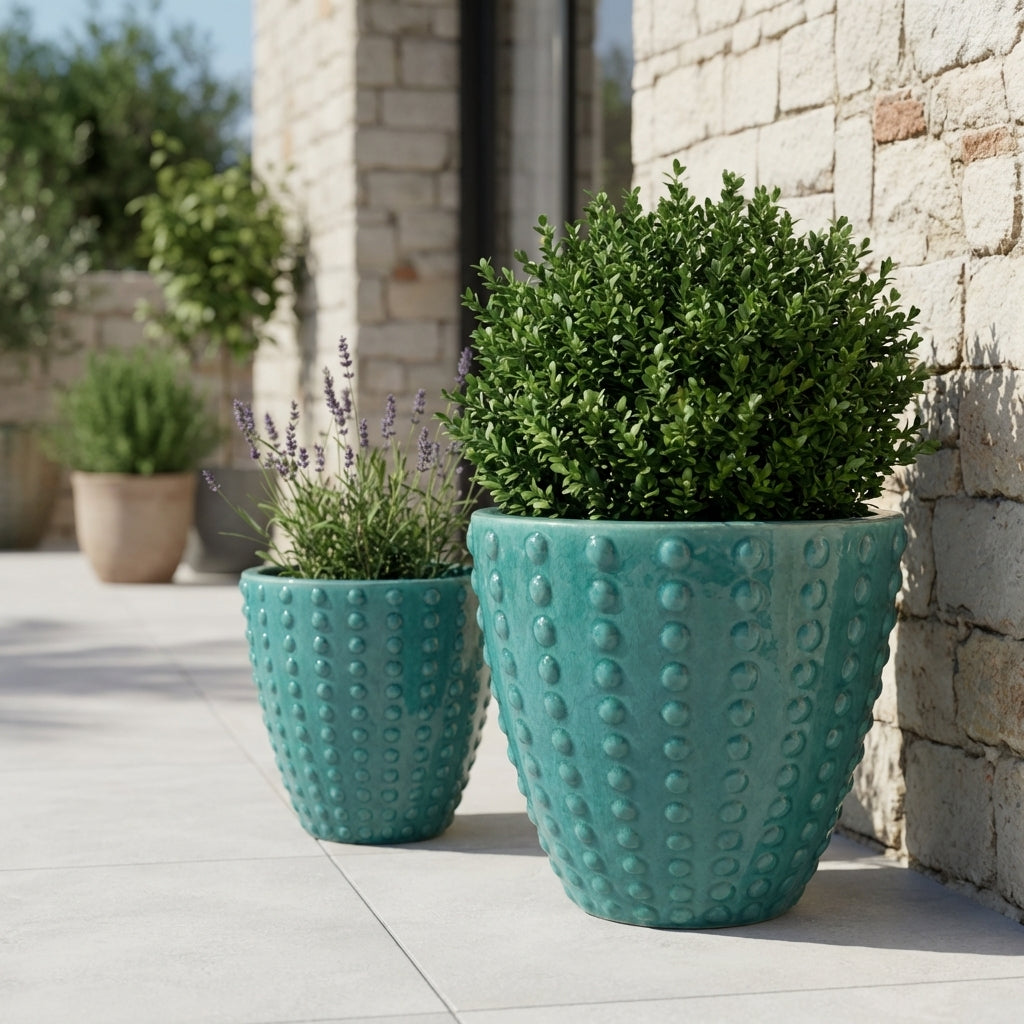 Detail na ručně vyráběný tyrkysový keramický květináč Attila z glazurované terakoty s reliéfní texturou na slunné středomořské terase.