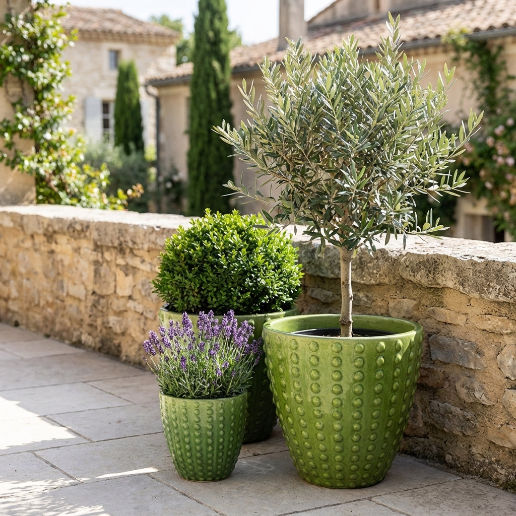 Ručně vyráběný glazurovaný keramický květináč Attila jablečně zelená z terakoty s výrazným reliéfem na slunné středomořské terase.
