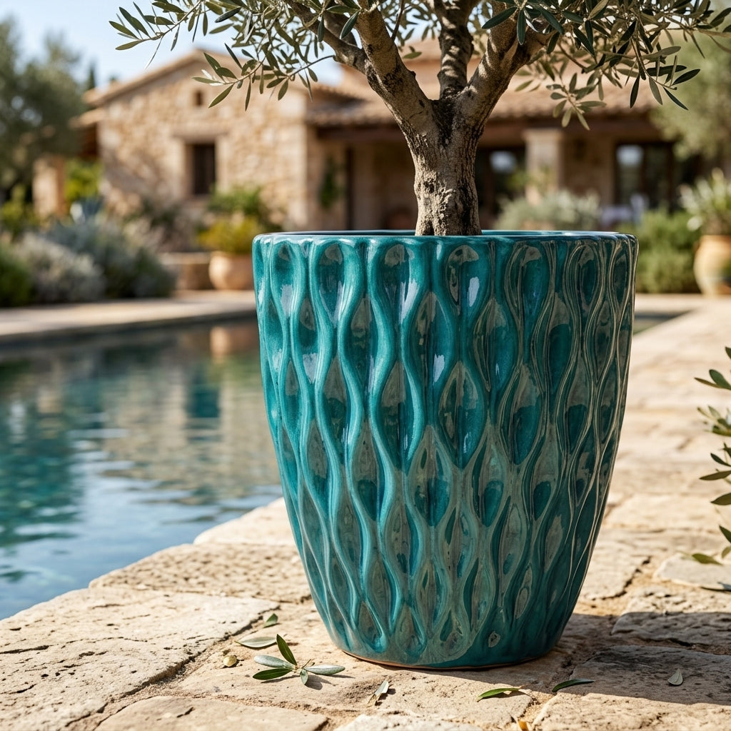 Detail na keramický květináč Monet Tyrkysový s olivovníkem na terase u bazénu, ručně vyráběný glazovaný květináč z terakoty s ozdobným reliéfem.