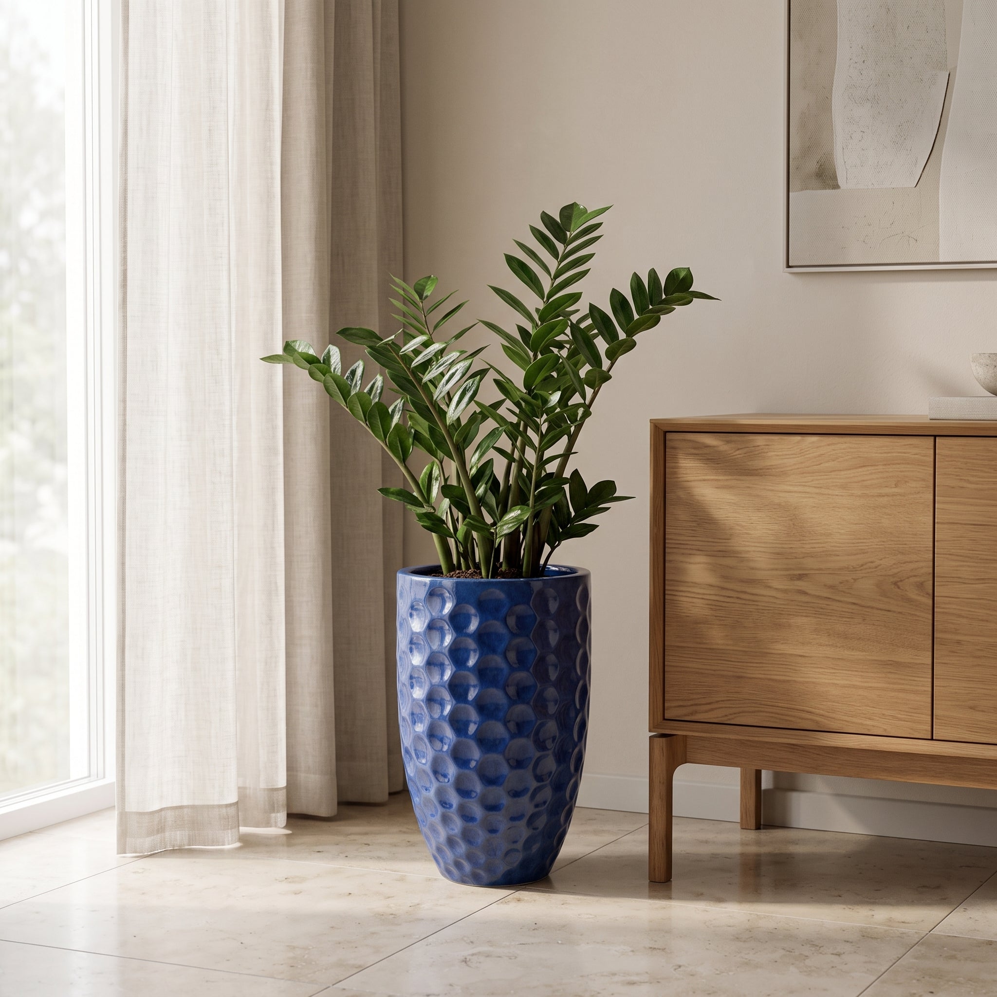 Azurově modrý keramický květináč MEROVEE L (30 x 45 cm) s rostlinou Zamioculcas v luxusním skandinávském interiéru.