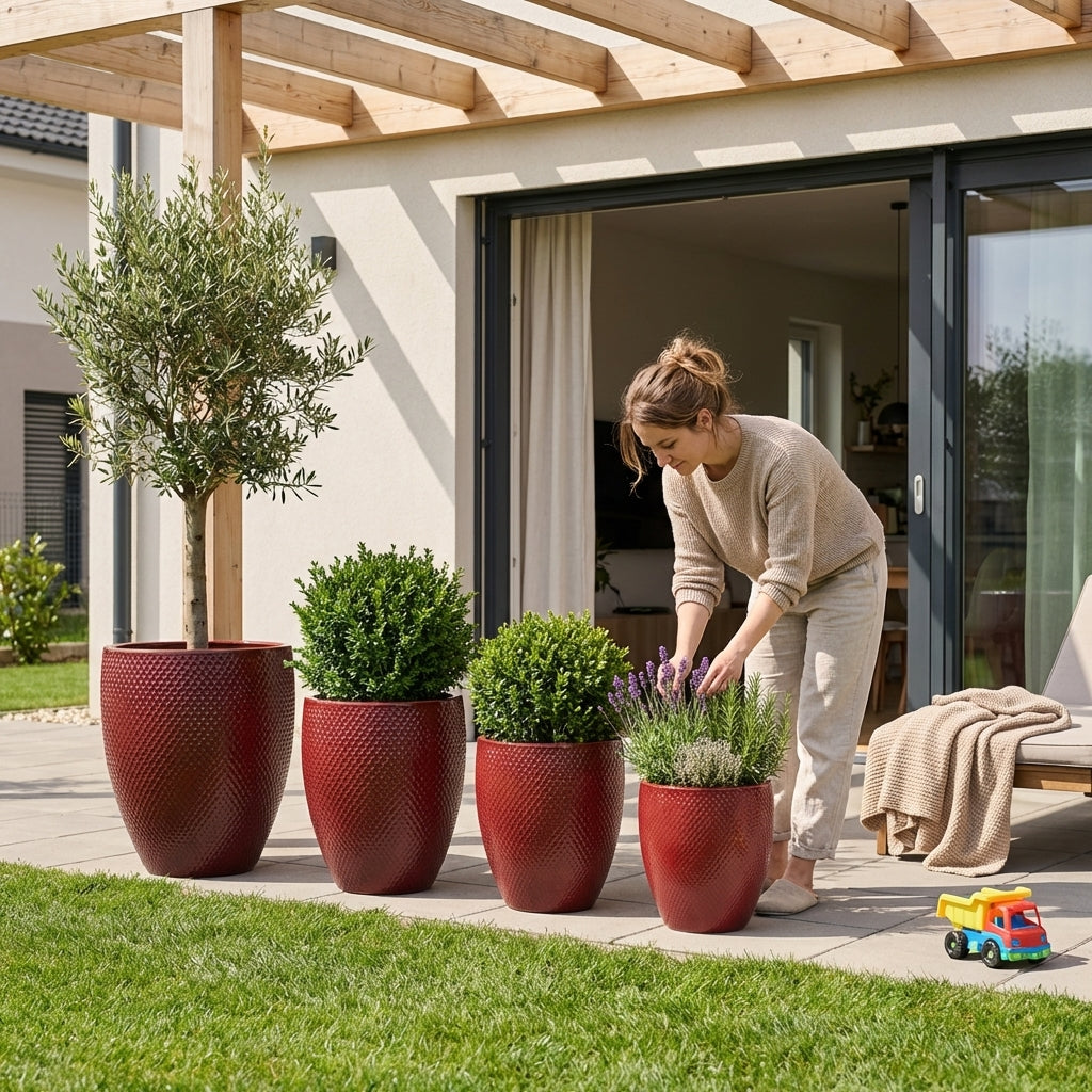 Detailní záběr na keramický květináč Signac - Císařská červená o výšce 52 cm osázený buxusem na slunné moderní terase.