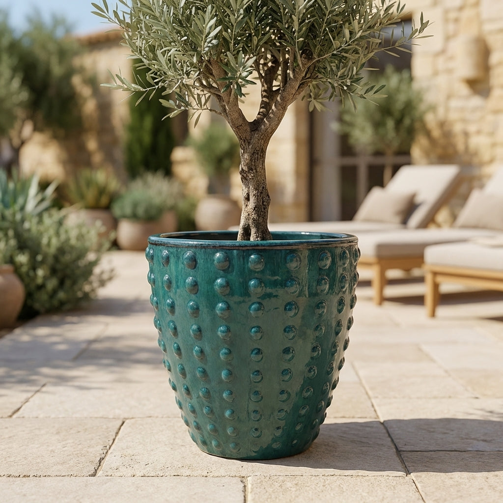 Detail na ručně vyráběný keramický květináč Attila v petrolejově modré barvě. Glazovaný terakotový květináč s reliéfní texturou a zasazenou levandulí na slunné kamenné terase.