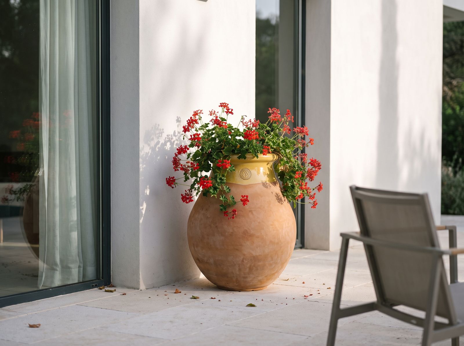 Biot z czerwonymi pelargoniami na tarasie nowoczesnej willi